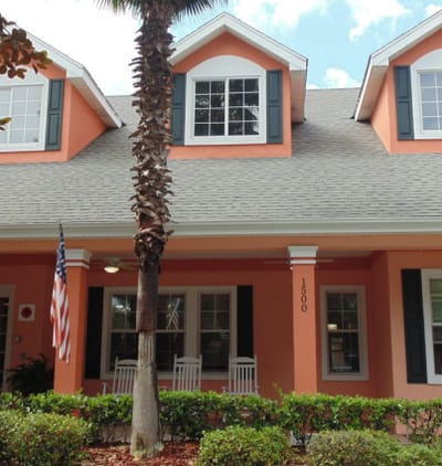 Exterior view of the facility with palm trees and porch