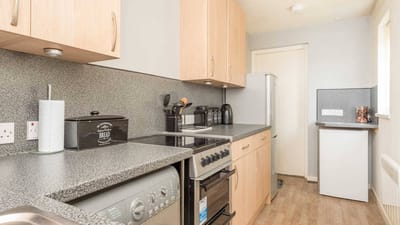 A modern kitchen area with appliances and cabinetry