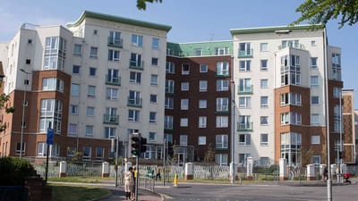 Exterior view of a senior living facility with residents outside