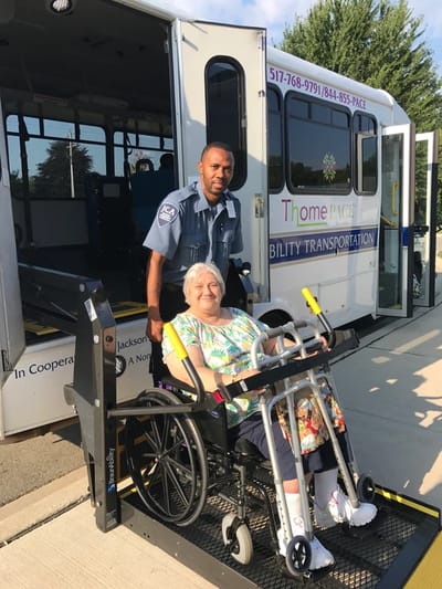 Support staff assisting a resident with transportation