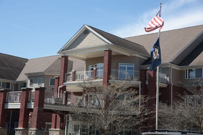 Exterior view of a senior living facility with flags