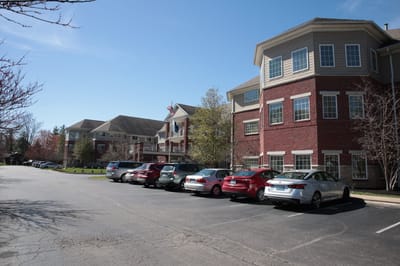 Exterior view of a senior living facility with parked cars