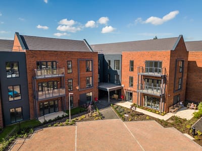 Exterior view of Albany Lodge with residents outdoors