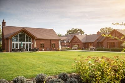 Exterior view of a nursing home facility with gardens