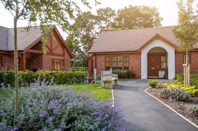 Exterior view of a senior living facility with gardens