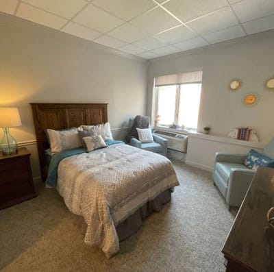 Cozy private resident room with a bed and chair