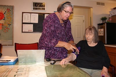 Staff member assisting a resident with health monitoring