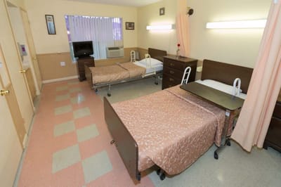 A shared resident room with two beds and basic furnishings