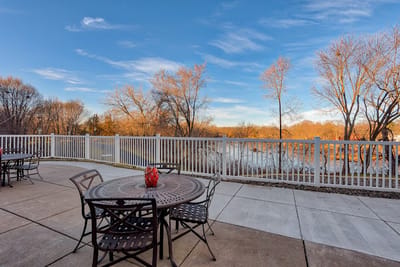 Outdoor seating area with view of trees and water