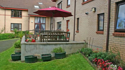 Outdoor seating area with patio umbrella and flowers