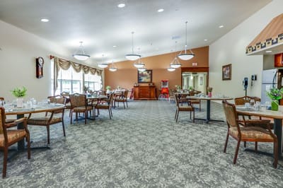 Bright dining room with tables and chairs set for meals