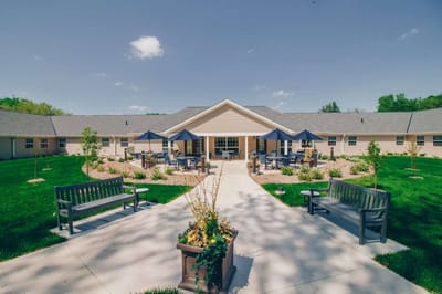 Exterior view of a senior living facility with gardens