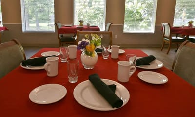 Dining table set with clean dishes and flowers