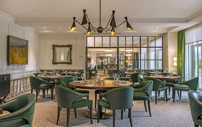 Elegant dining room with round tables and green chairs