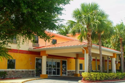 Exterior view of Balmoral Assisted Living facility with palm trees