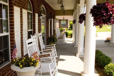 Rocking chairs on a porch with potted plants
