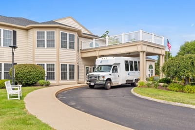 Facility entrance with transportation vehicle and landscaping