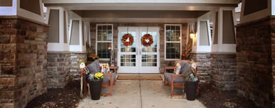 Welcoming entrance of a senior living facility decorated for fall