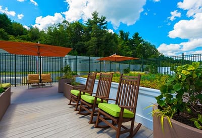 Outdoor patio seating with rocking chairs and umbrellas