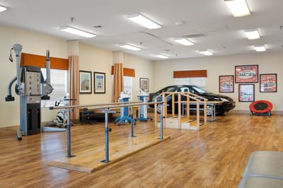 Rehabilitation room with gym equipment and therapy setup