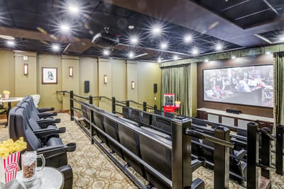 Interior photo of a cozy movie theater with seating and popcorn