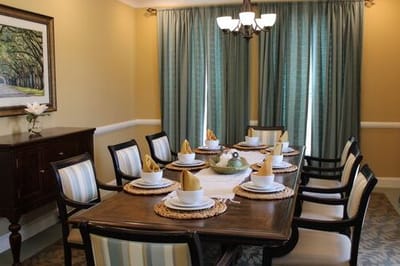 Dining room set up for a meal with decorative table settings