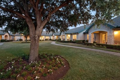 Exterior view of assisted living facility with landscaped grounds