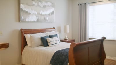 A well-decorated resident room with a bed and window