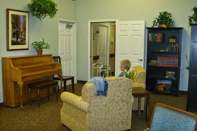 A resident enjoying the common area with a piano