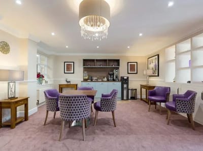Bright common area with purple chairs and a coffee station
