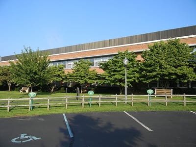 Exterior view of the building with trees and parking area