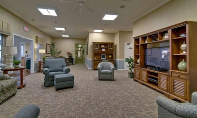 Common area with seating and TV in a senior living facility