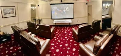 Seating area in a cozy movie room with a screen
