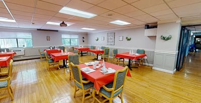 Bright dining room with red tablecloths and seating