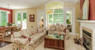 Bright common area with floral sofas and large windows