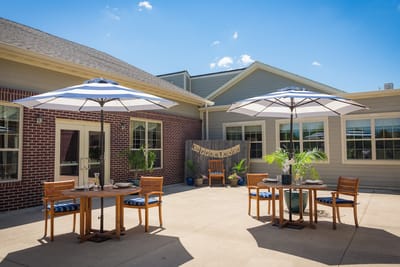 Outdoor area with tables and umbrellas in a senior living facility