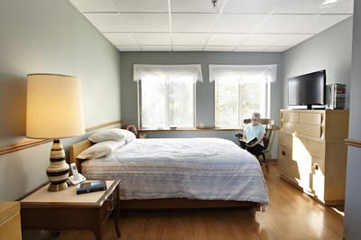 Resident reading in a well-lit private room