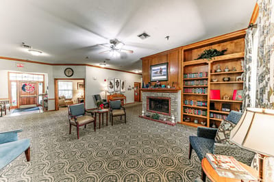 Common area with seating and fireplace in a senior living facility.