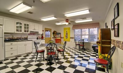 Bright common area with checkered flooring and kitchen
