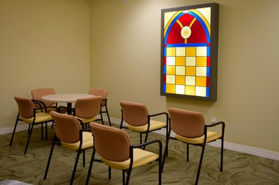 Common area with chairs and stained glass feature
