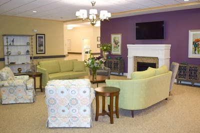 Common area with green sofas and a fireplace