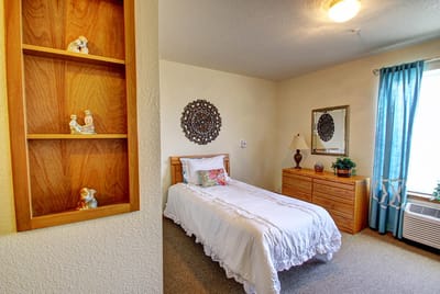 Cozy single bedroom with decor and a window.