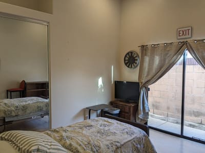 Private resident room with bed, TV, and exit sign