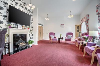 Common area with purple chairs and a fireplace