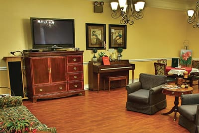 Common area with seating and piano in a warm-colored room