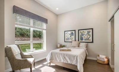 A cozy private room with a bed and chair