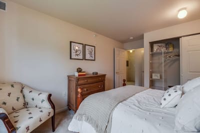 A cozy private resident room with a bed and seating area