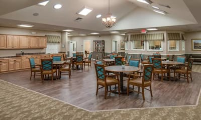 Dining area with tables and chairs in a senior living facility