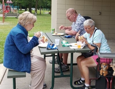 Residents enjoying lunch outside at a picnic table
