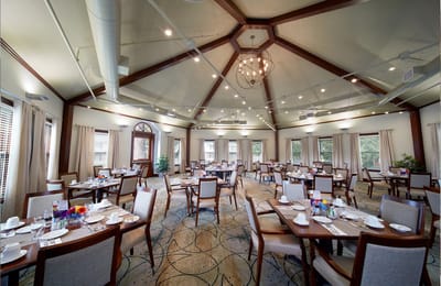 Dining room setup with tables and chairs for residents